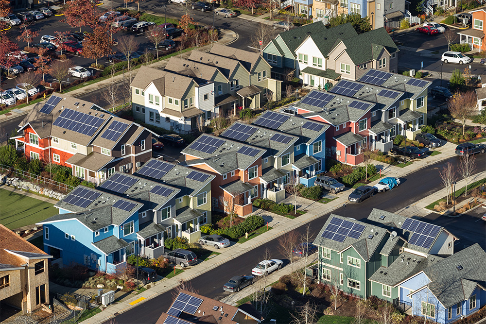 Large collection of solar panels attached to the roofs of multiple public housing buildings