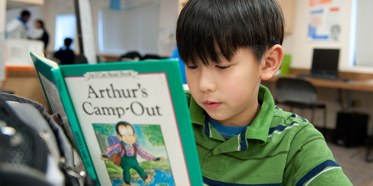 Child reading book in learning center