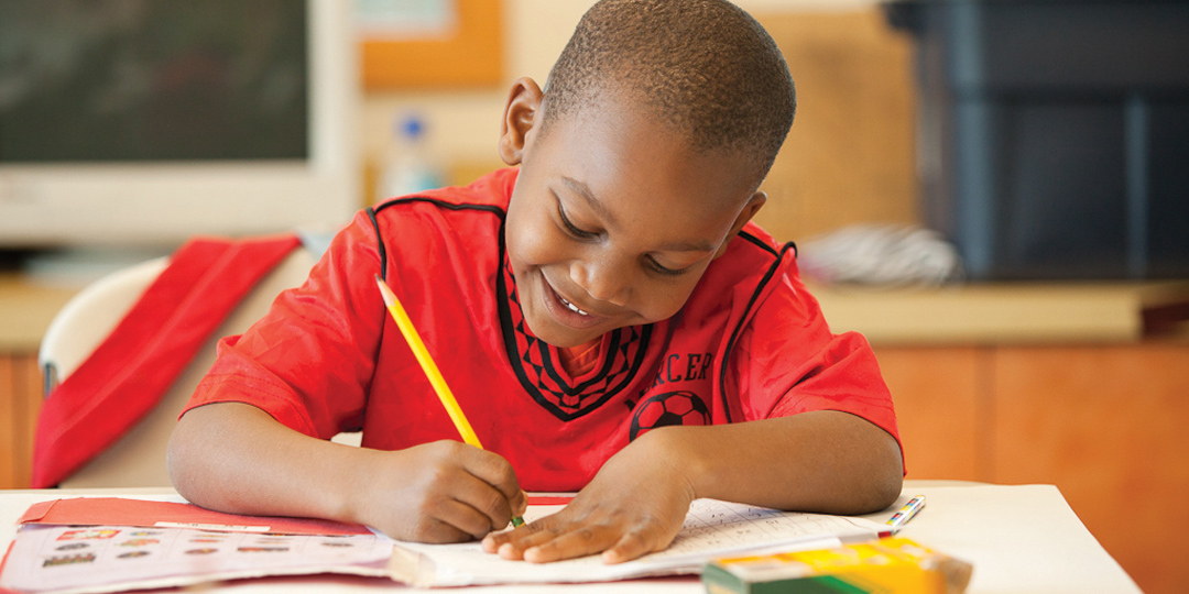 Boy writing on paper at his desk